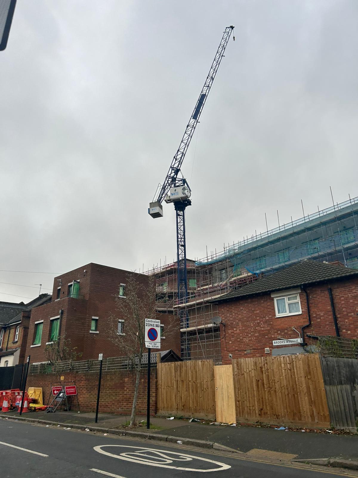 Tower crane standing over a residential construction site on a grey day